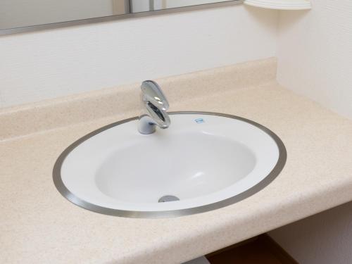 a white sink in a bathroom with a mirror at Tabist Hachi no Oyado Numadate Heights in Odate