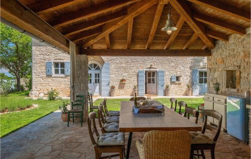 a patio with a table and chairs under a wooden roof at Villa Roveria in Butkovići
