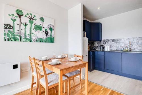 a kitchen with a wooden table and blue cabinets at Large 2 Bed 2 Bath Central Manchester in Manchester