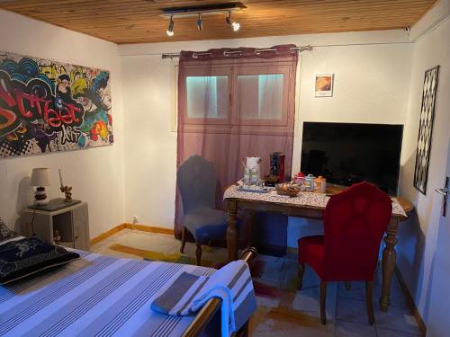 - une chambre avec un bureau avec deux chaises et une télévision dans l'établissement Bienvenue chez les Anges, à Cournon-dʼAuvergne