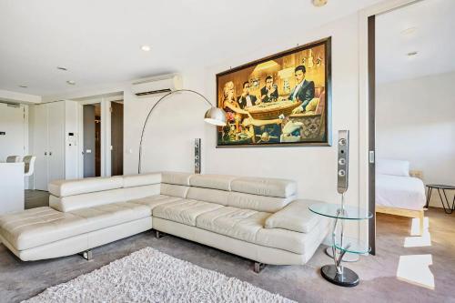 a living room with a couch and a painting on the wall at Riviera Edgewater Maribyrnong in Melbourne