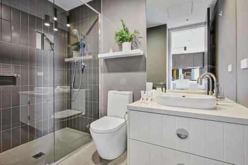 a bathroom with a toilet and a sink and a shower at Riviera Edgewater Maribyrnong in Melbourne