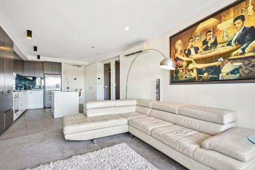 a living room with a couch and a painting on the wall at Riviera Edgewater Maribyrnong in Melbourne
