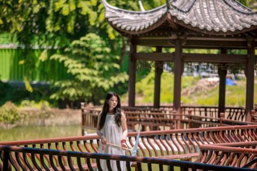 a young girl is walking across a bridge at 三亚南山树屋隐世酒店 in Shangsimacun