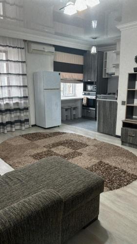 eine große Küche mit einem weißen Kühlschrank und einem Teppich in der Unterkunft Апартамент in Qaraghandy