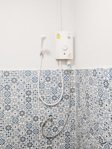a shower in a bathroom with blue and white tiles at Moochi Relax L'Assommior in Ban Na Song