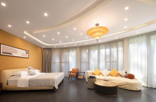a hotel room with two beds and a couch at 三亚南山树屋隐世酒店 in Shangsimacun