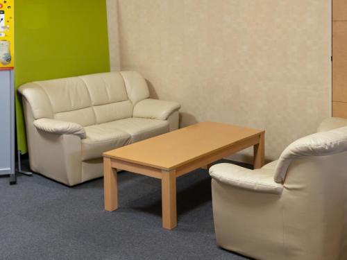a waiting room with a couch and a table and a chair at Tabist Hachi no Oyado Numadate Heights in Odate