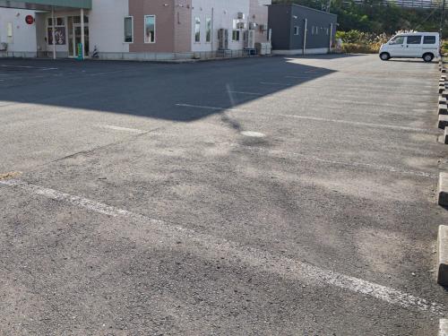a parking lot with a white van parked in it at Tabist Hachi no Oyado Numadate Heights in Odate