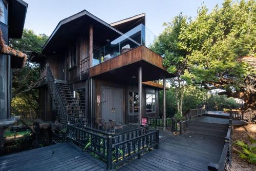 a house with a deck and a balcony at 三亚南山树屋隐世酒店 in Shangsimacun