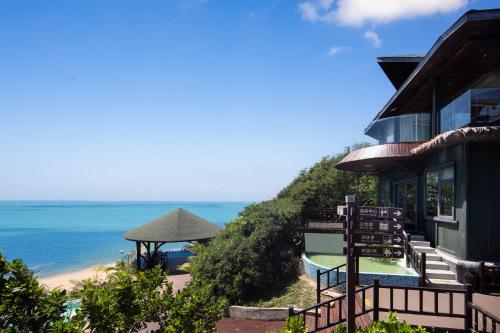 a house with a view of the beach and the ocean at 三亚南山树屋隐世酒店 in Shangsimacun