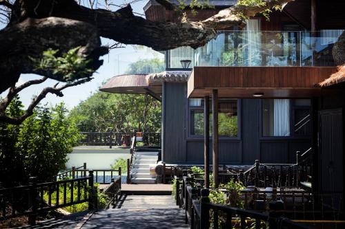 a porch of a house with a table and chairs at 三亚南山树屋隐世酒店 in Shangsimacun