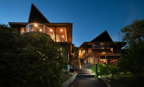 a house with a staircase leading up to it at night at 三亚南山树屋隐世酒店 in Shangsimacun
