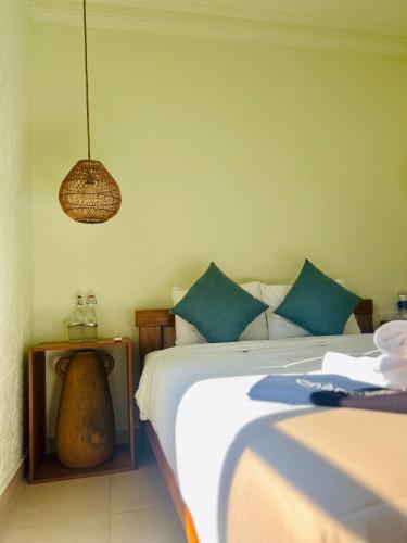 a bedroom with a bed with blue pillows and a lamp at New Yêu Biển homestay in Vĩnh Hy