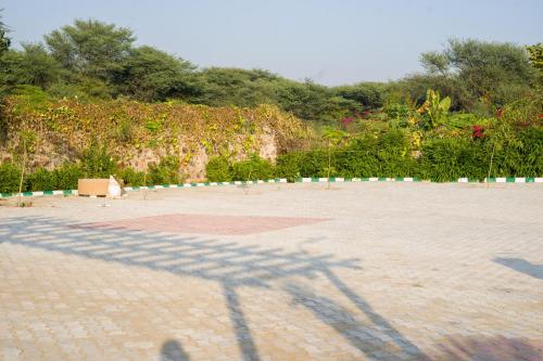 a shadow of a cross on the ground at ELIVAAS 5 BHK With Pvt Pool & Garden - Zenora in Gurgaon