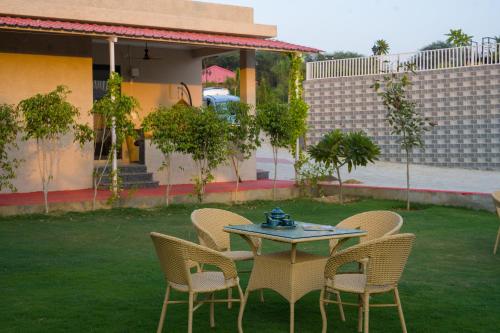 a table and chairs sitting on a lawn with a table and chairs at ELIVAAS 5 BHK With Pvt Pool & Garden - Zenora in Gurgaon