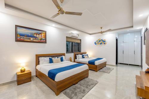 a bedroom with two beds and a tv at ELIVAAS 5 BHK With Pvt Pool & Garden - Zenora in Gurgaon