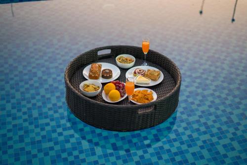 a breakfast tray with breakfast foods on a table at ELIVAAS 5 BHK With Pvt Pool & Garden - Zenora in Gurgaon
