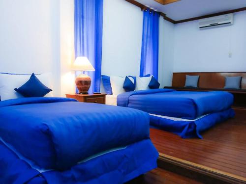 two beds in a room with blue sheets at Samui Wooden Hill Resort in Lamai