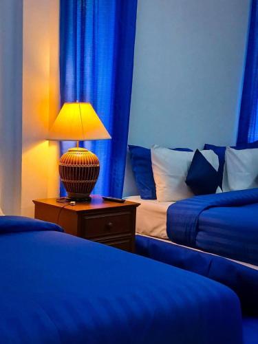 a bedroom with two beds and a lamp on a night stand at Samui Wooden Hill Resort in Lamai