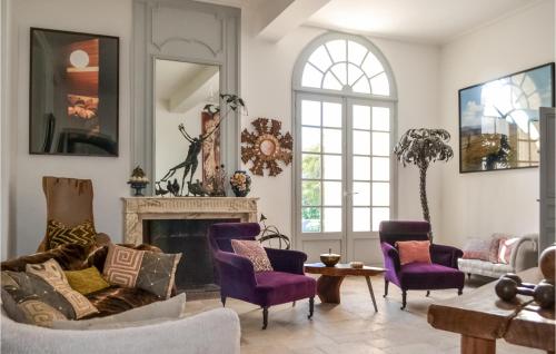 a living room with purple chairs and a fireplace at Amazing Home In Léognan With Sauna in Léognan
