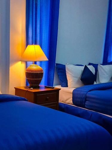 a bedroom with two beds and a lamp on a night stand at Samui Wooden Hill Resort in Lamai