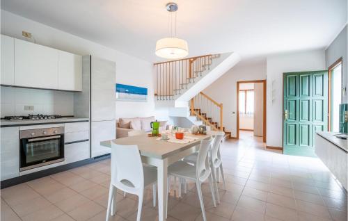 Una cocina y un comedor con mesa y sillas. en 3 Bedroom Gorgeous Home In Albarella Ro, en Isola Albarella