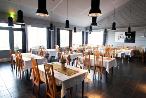 une salle à manger avec des tables et des chaises dans un restaurant dans l'établissement Hotelli Pikku-Syöte, à Syöte