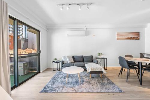 a living room with a couch and a table at Convenient East Perth Stay with Free Parking in Perth