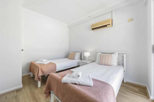 a room with two beds with towels on top of them at Convenient East Perth Stay with Free Parking in Perth