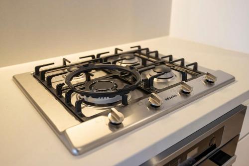 a stove top oven with a black burner at Modern 2BR Abode with Balcony View Gym Access in Glen Waverley