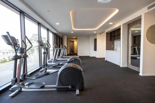 a gym with treadmills and ellipticals in a room with windows at Modern 2BR Abode with Balcony View Gym Access in Glen Waverley