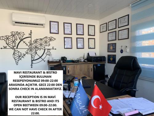 an office with a desk with a sign on the wall at Mavi Restaurant & Apartments 2 in Didim