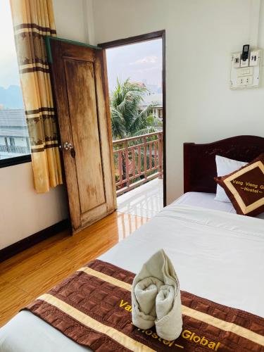 a hotel room with two beds and a balcony at Vang vieng guesthouse in Vang Vieng