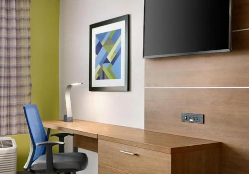 a room with a desk with a tv and a chair at Holiday Inn Express & Suites Salisbury by IHG in Salisbury