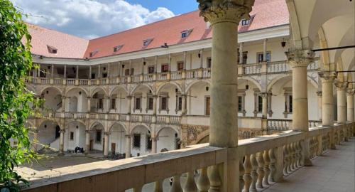 a large building with columns and a balcony at Apartament Brzeg in Brzeg