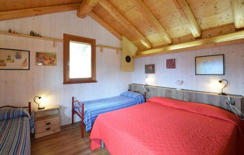 a bedroom with two beds and a window and wooden ceilings at Alla Cocca in San Donato