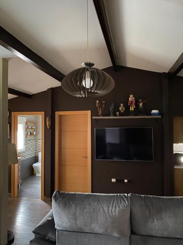 Cedillo del CondadoにあるVilla Cedillo con piscina privada y barbacoa cerca Puy du Fou y Parque Warnerのソファと薄型テレビのあるリビングルーム