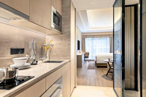 a kitchen with a counter and a dining room at Marriott Executive Apartments Hangzhou Yuhang in Hangzhou
