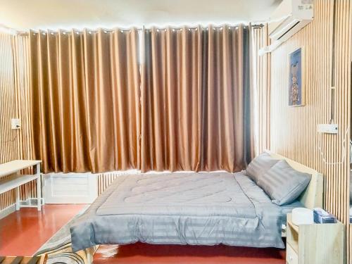 a bedroom with a bed in front of a large window at Moochi Relax L'Assommior in Ban Na Song