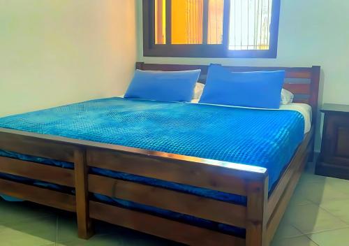a bed with blue sheets and pillows in a room at Beach View Apartment Oued Laou in Oued Laou