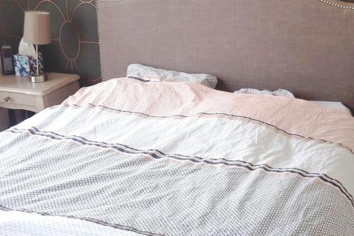 - un lit avec une couette blanche au-dessus dans l'établissement Appartement chaleureux avec terrasses, à Annecy