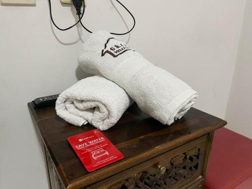 a towel on top of a table with a book at RedDoorz Near Alun Alun Kota Wisata Batu in Batu