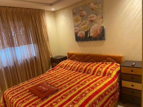 a bedroom with a bed with a colorful comforter at Panoramic view Condo Mehdia in Kenitra