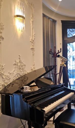 a piano sitting in a room with a lamp at Hotel Ambasada QTA in Patza-Kuqani