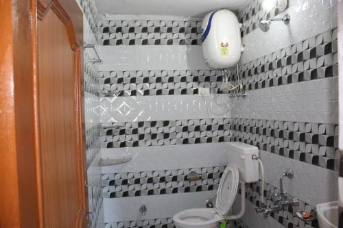 a bathroom with a toilet and a sink at Para Valley Home Stay in Bīr