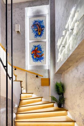 a set of stairs with paintings on the wall at Aurora Hills Hotel in Plovdiv