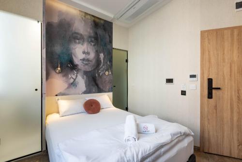 a bedroom with a bed with a large painting on the wall at Aurora Hills Hotel in Plovdiv