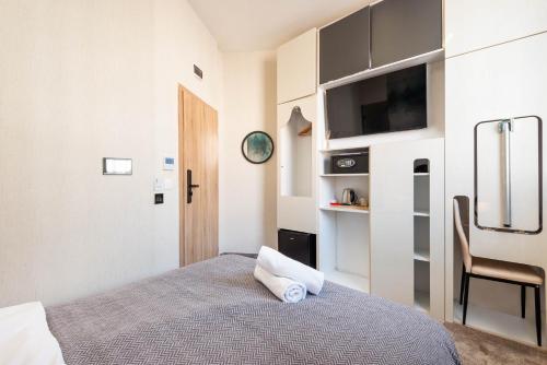 a bedroom with a bed and a flat screen tv at Aurora Hills Hotel in Plovdiv