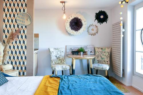 - une chambre avec une table, deux chaises et un lit dans l'établissement L'ILLUSIONISTE studio dans le Suquet avec aperçu mer, à Cannes